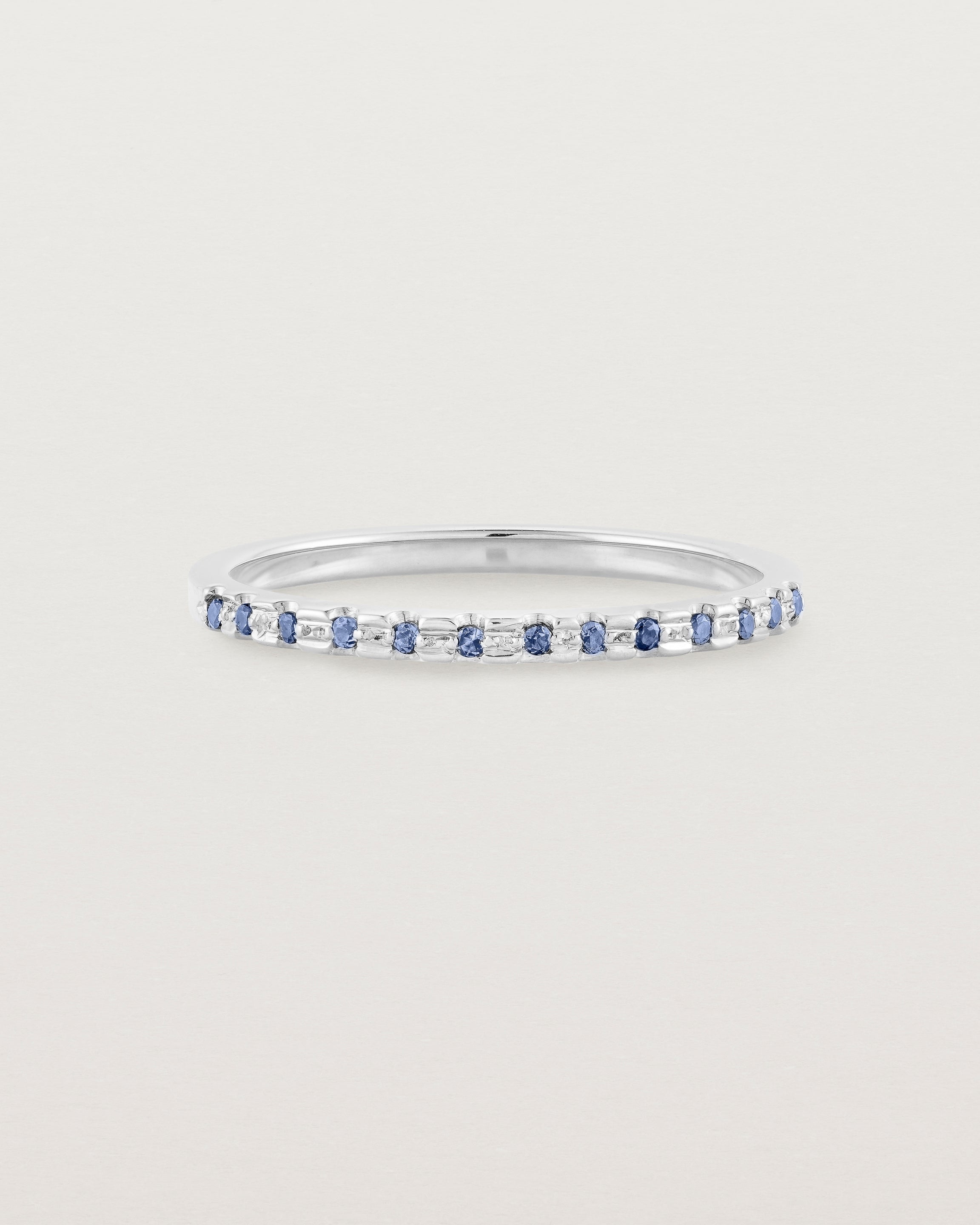 A fine white  gold wedding ring with thirteen blue sapphires