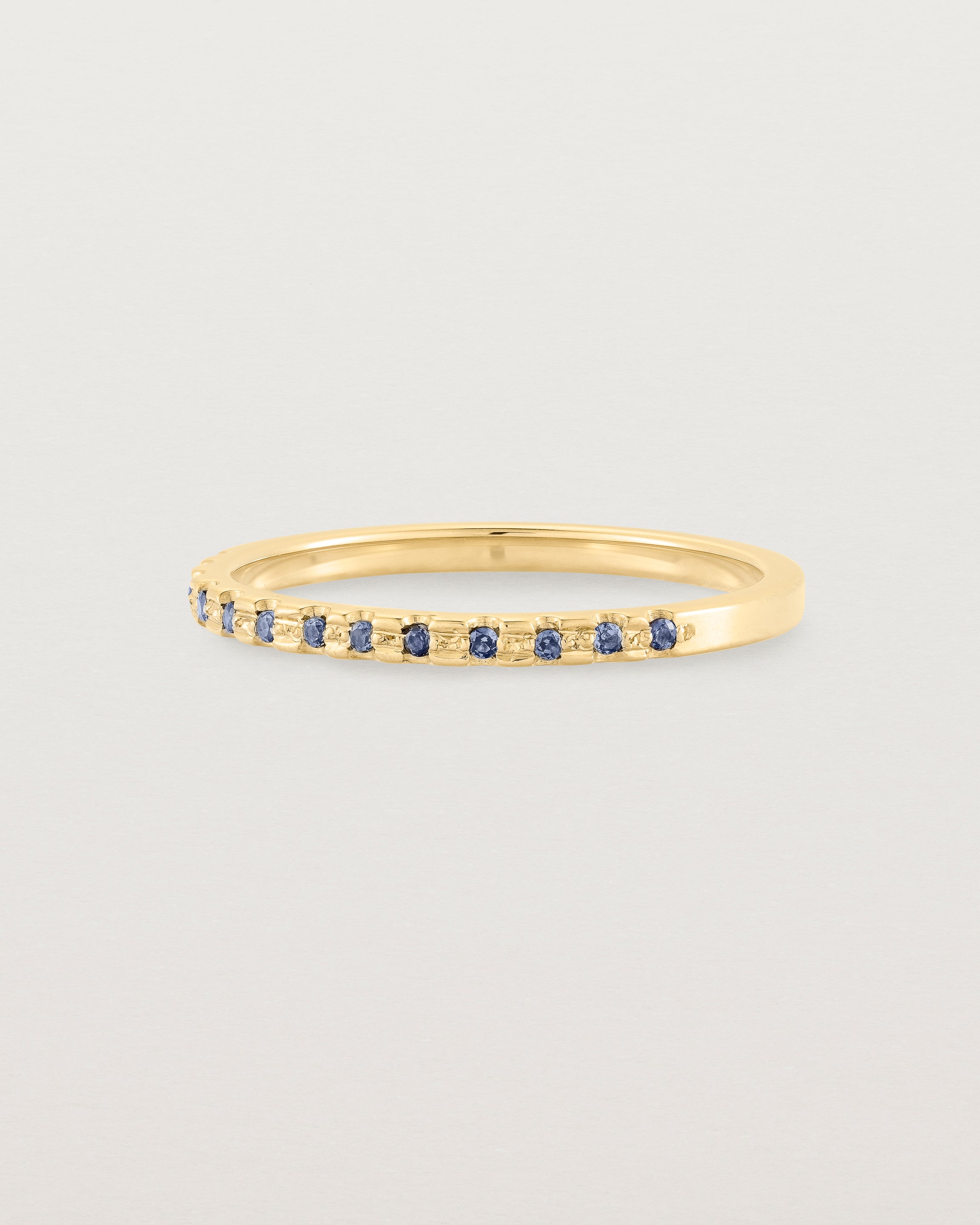 A fine yellow gold wedding ring with thirteen blue sapphires