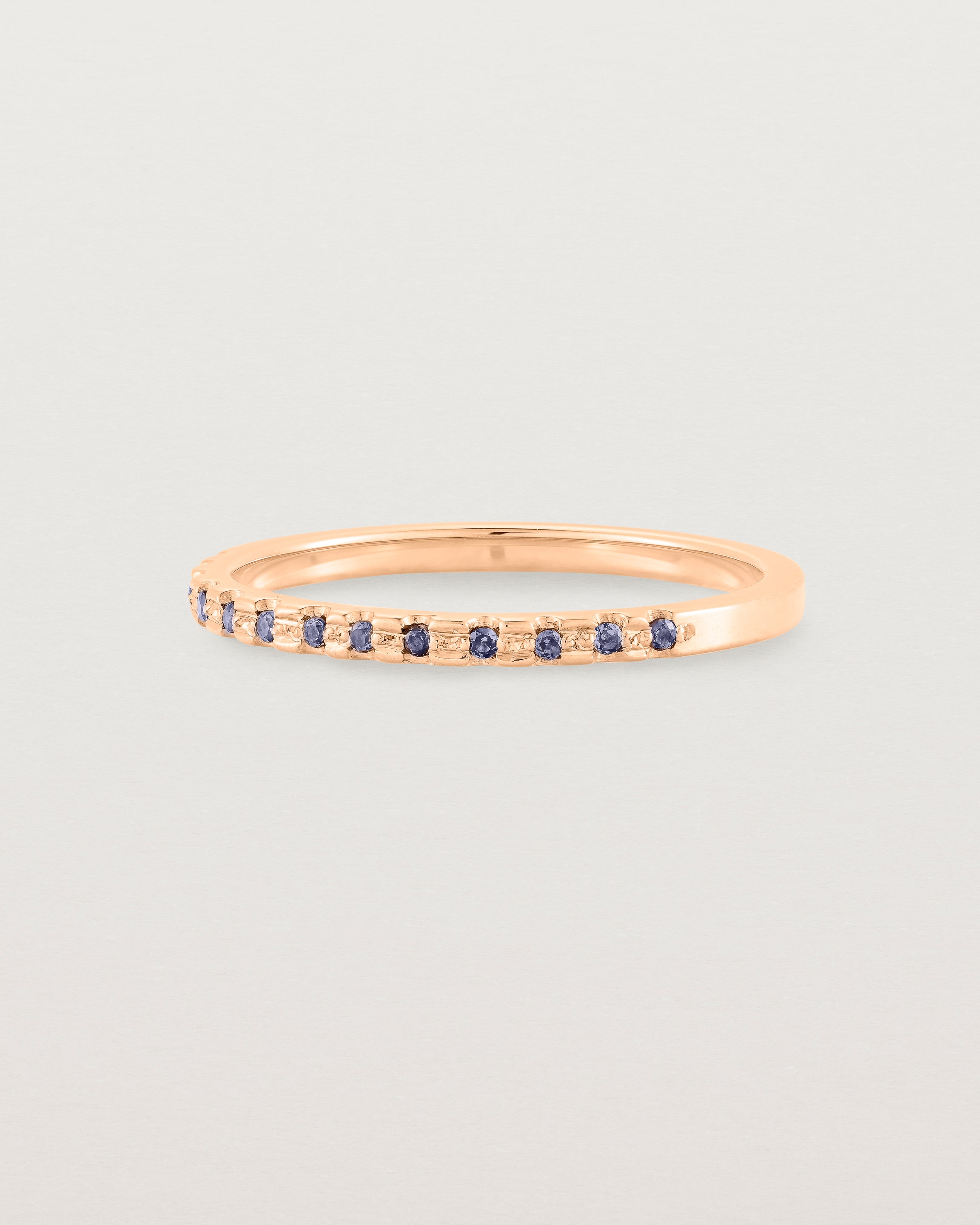 A fine rose gold wedding ring with thirteen blue sapphires