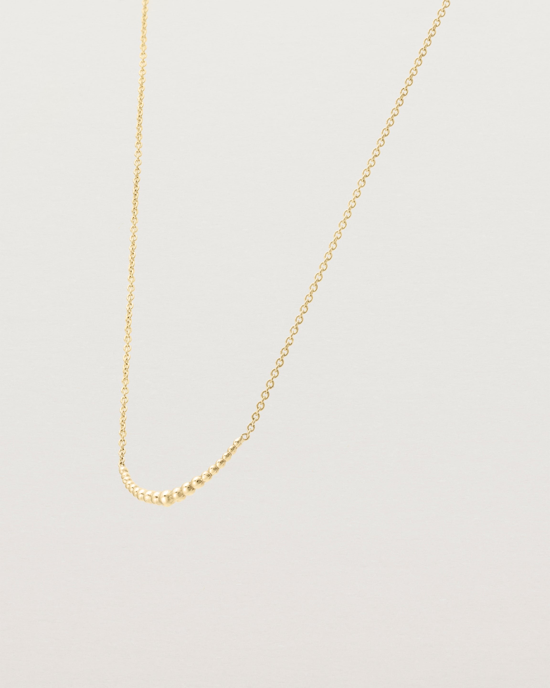Angled view of the Crescent Necklace in yellow gold.