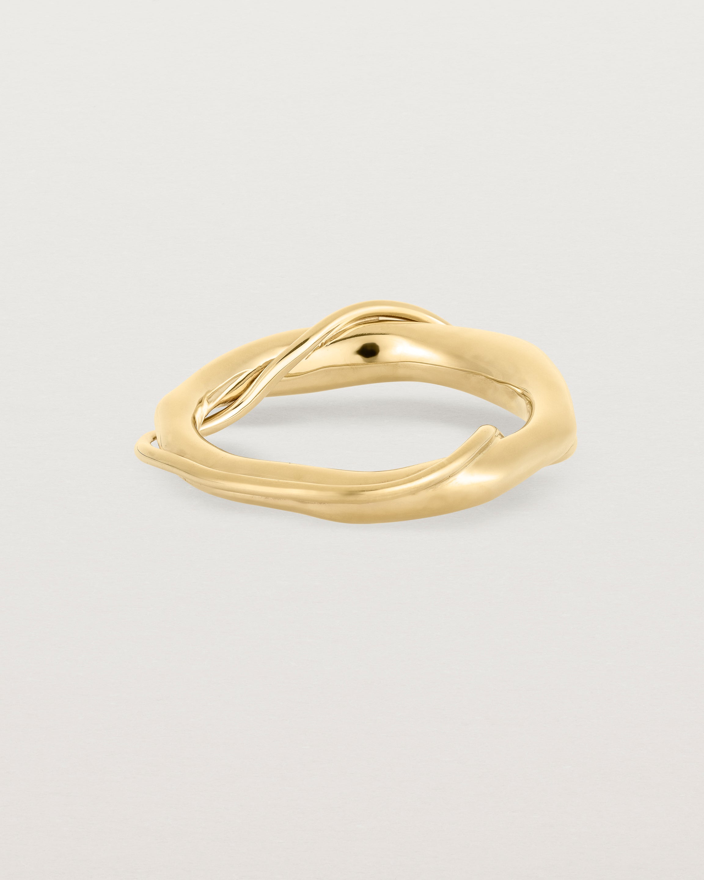 A yellow gold ring featuring two entwined metal bands