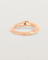 A rose gold ring featuring two entwined metal bands