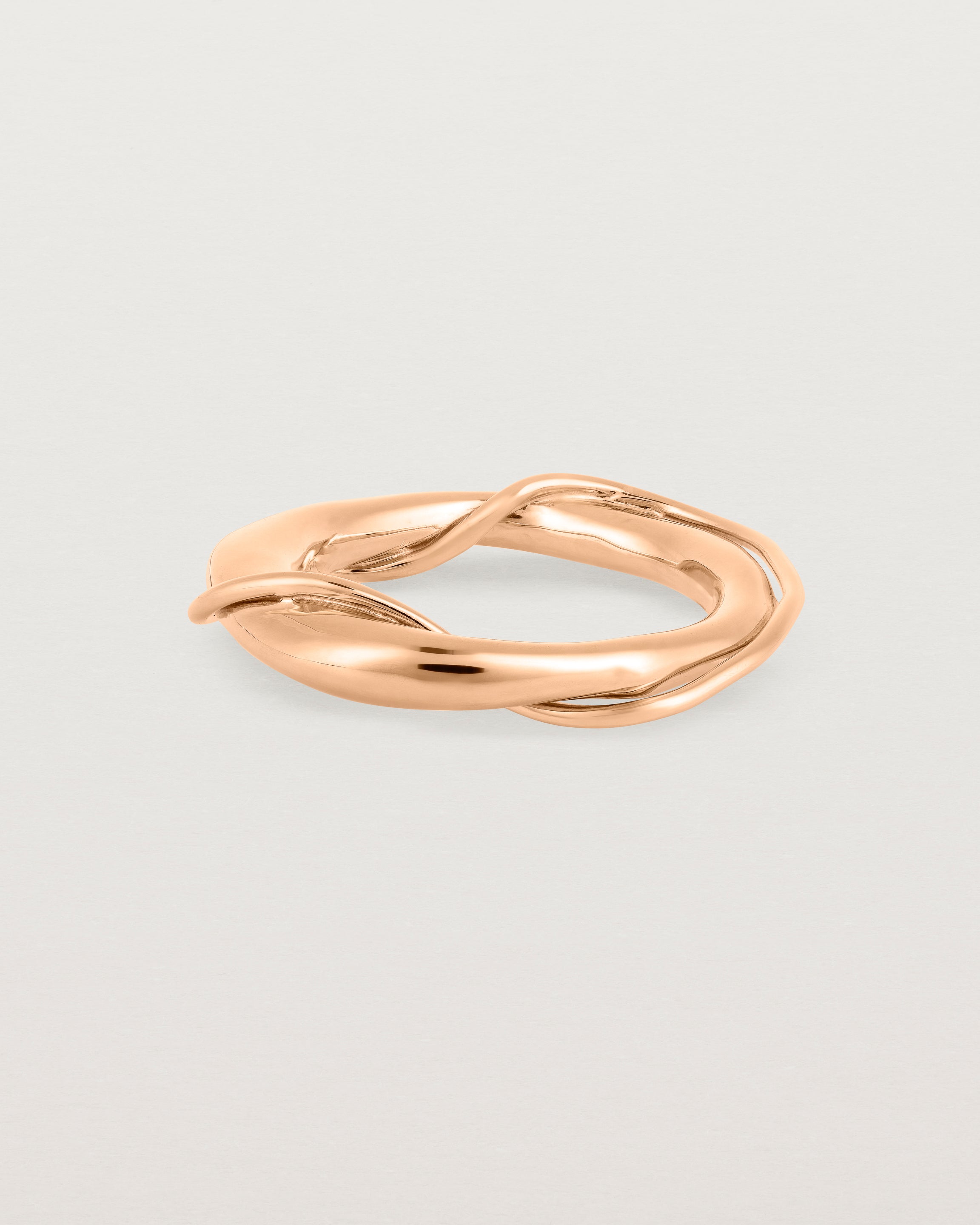 A rose gold ring featuring two entwined metal bands