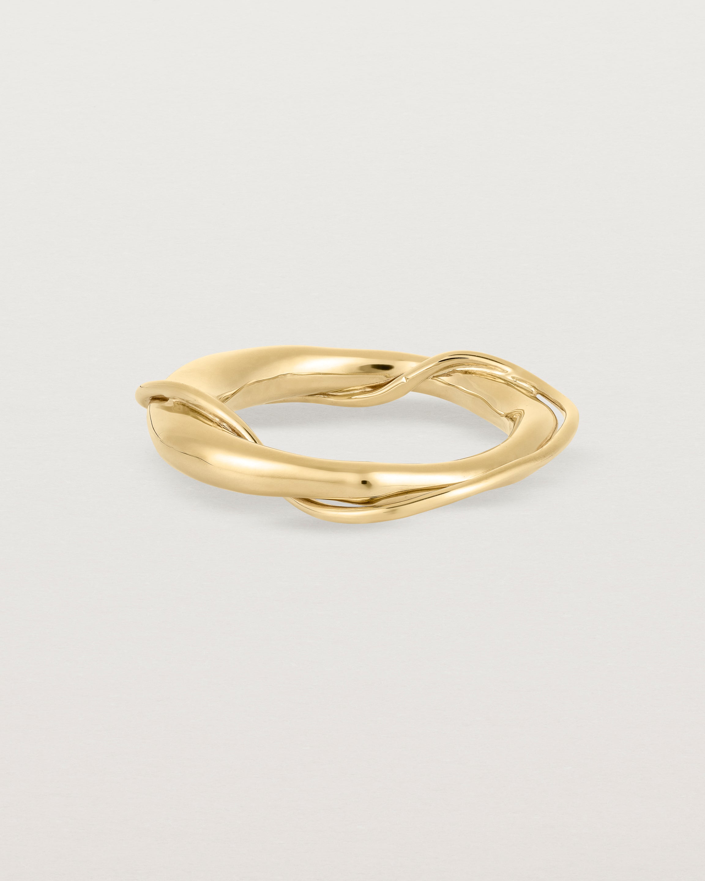 A yellow gold ring featuring two entwined metal bands