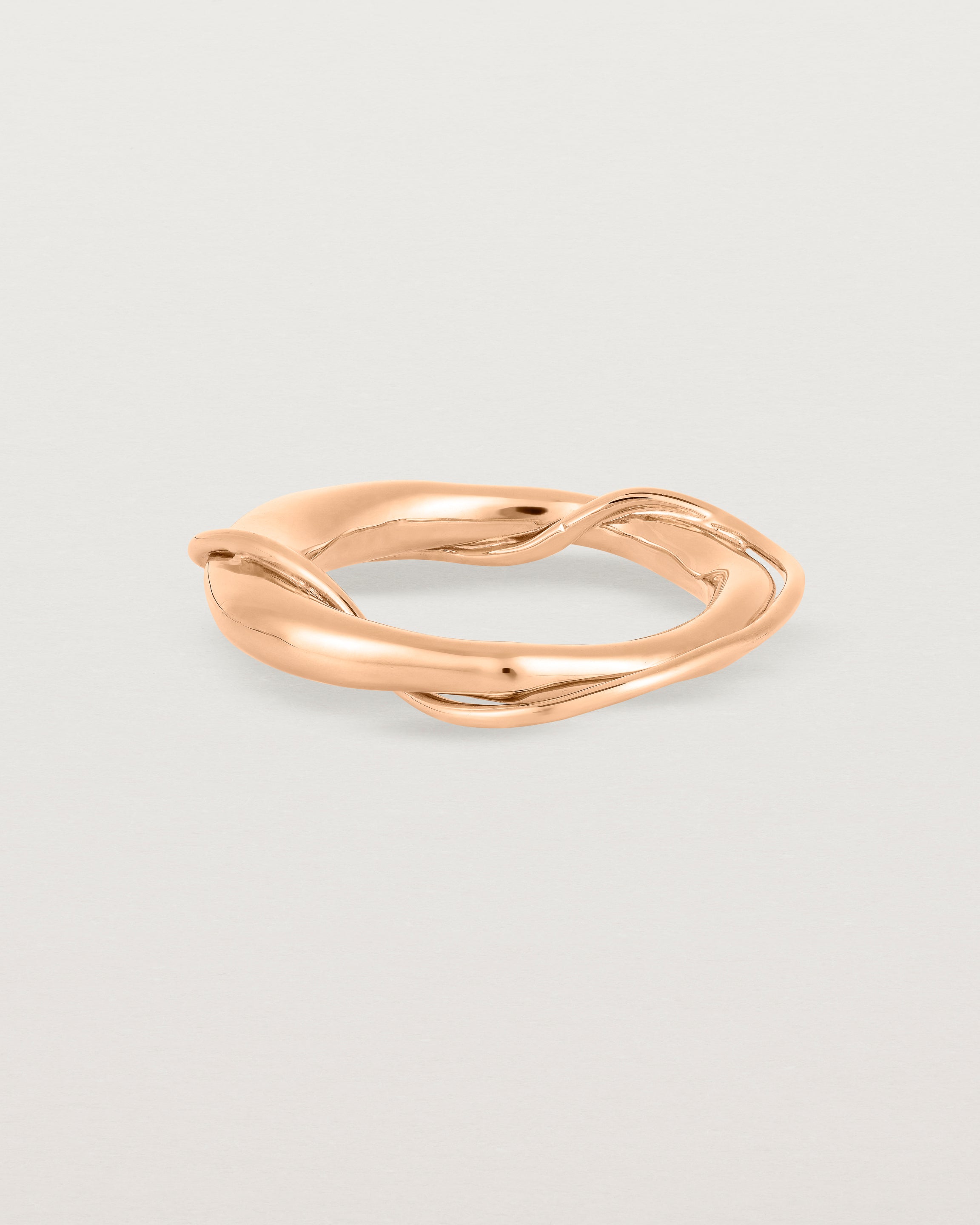 A rose gold ring featuring two entwined metal bands