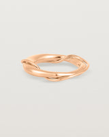 A rose gold ring featuring two entwined metal bands