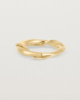 A yellow gold ring featuring two entwined metal bands