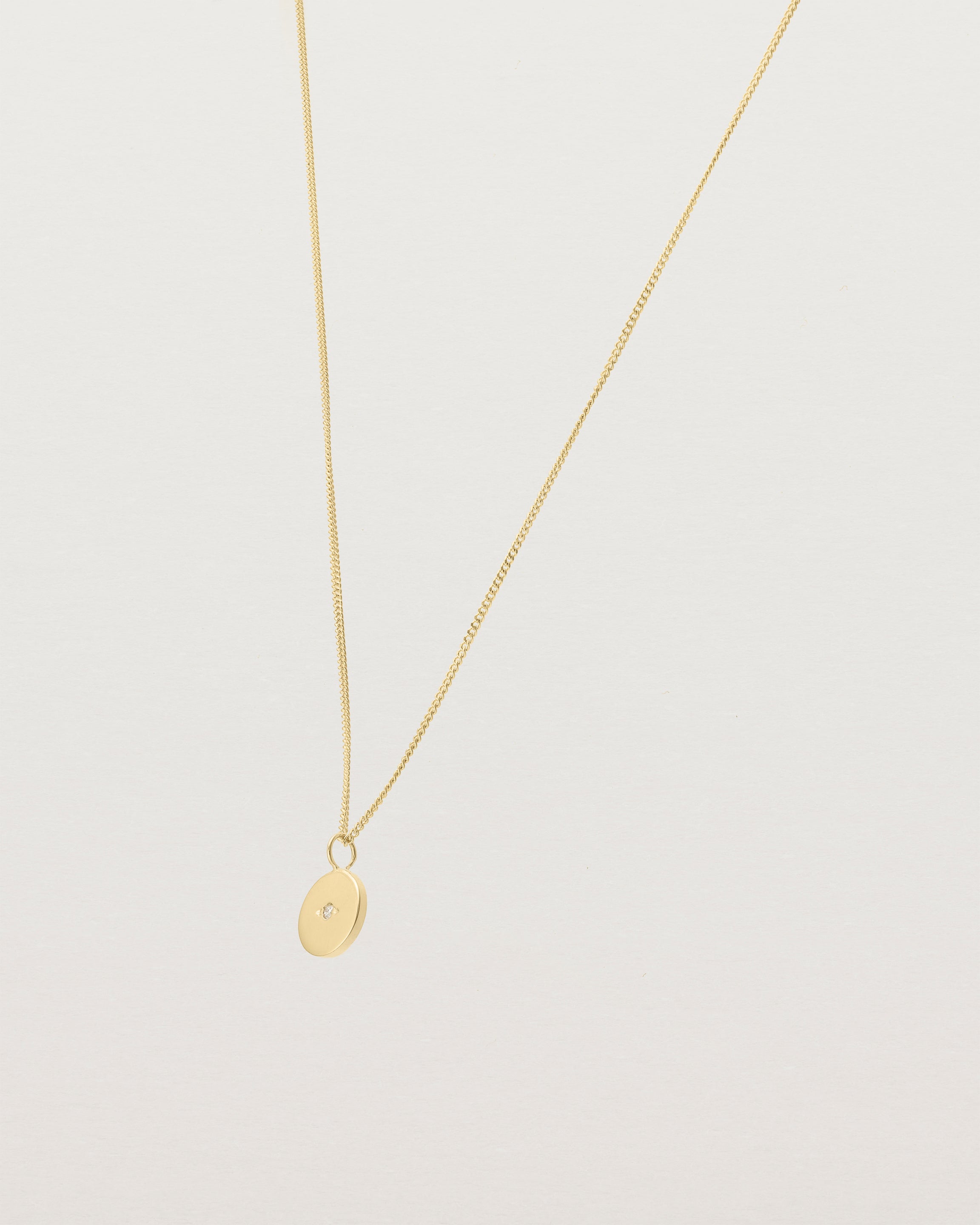 Angled view of the Eily Necklace with a diamond in yellow gold.