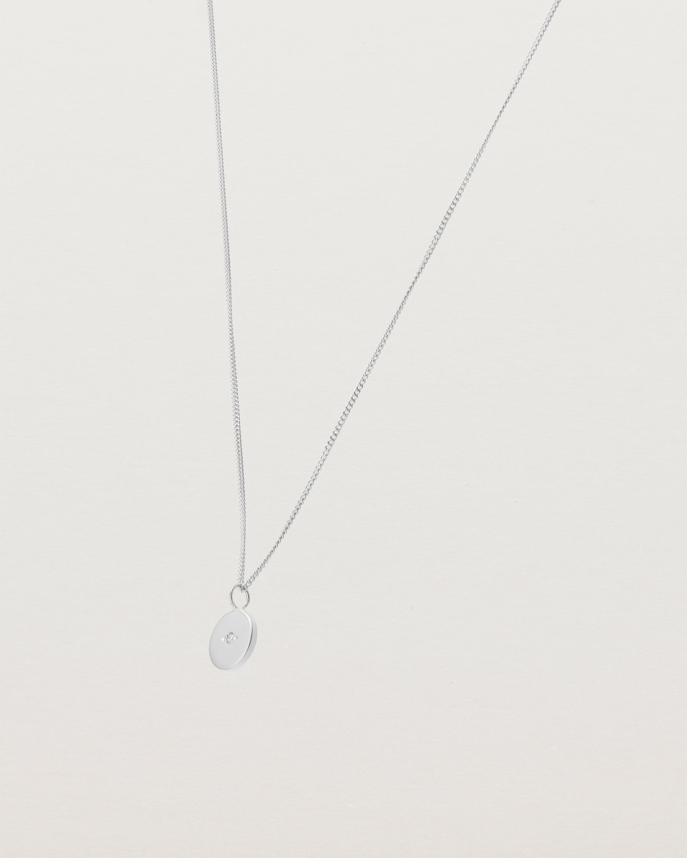 Angled view of the Eily Necklace with a diamond in white gold.
