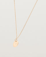 Angled view of the Mini Initial Necklace in Rose Gold.