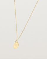 Angled view of the Mini Initial Necklace in Yellow Gold.
