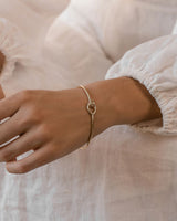 A woman wearing the Oana Bangle in yellow gold.