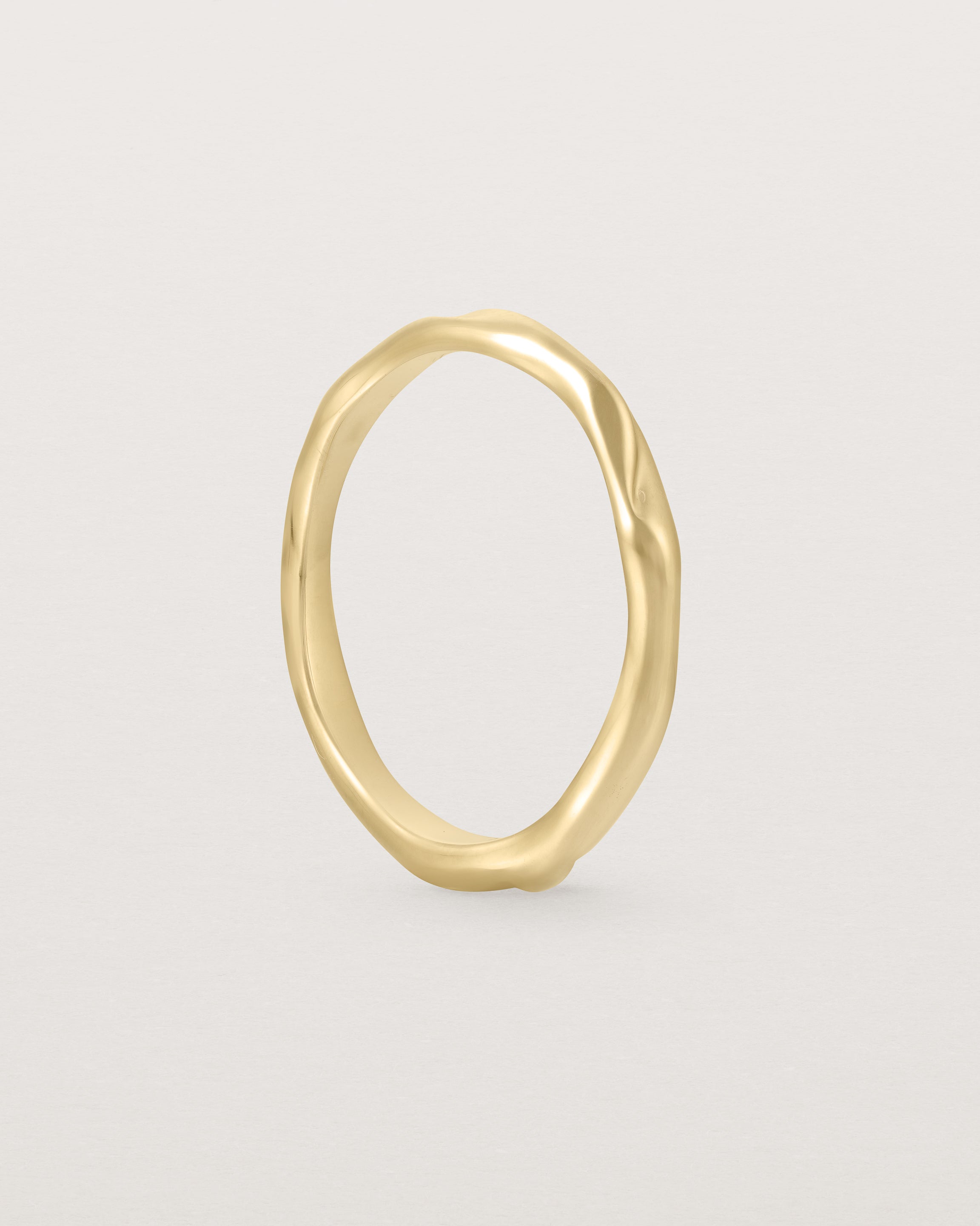 The Organic Wedding Ring | 2mm in Yellow Gold standing.