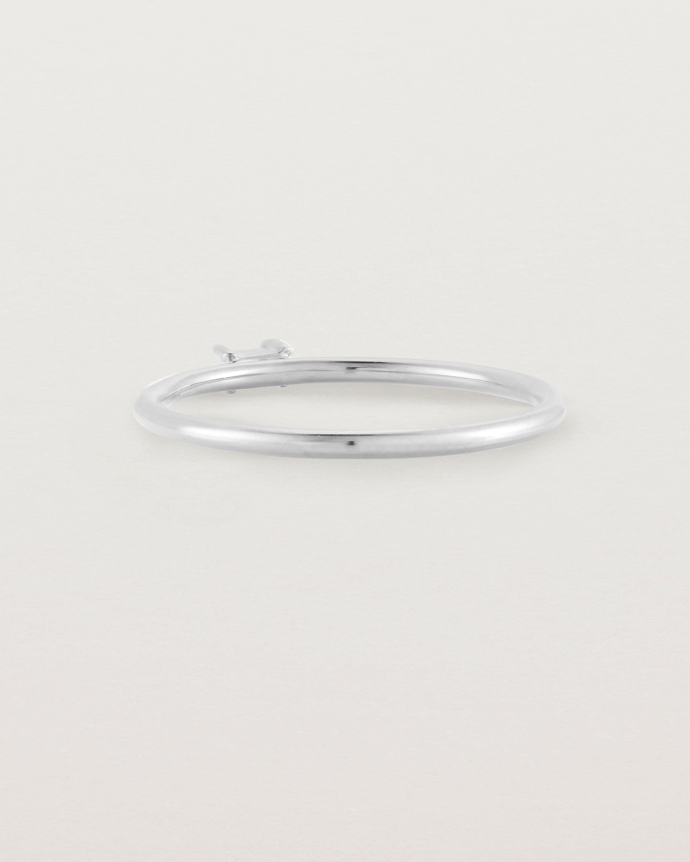 A fine silver ring featuring an emerald cut pale blue sapphire set in the centre of the band