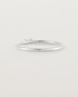 A fine silver ring featuring an emerald cut pale blue sapphire set in the centre of the band