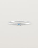 A fine silver ring featuring an emerald cut pale blue sapphire set in the centre of the band