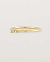 fine yellow gold ring featuring a emerald cut pale blue sapphire