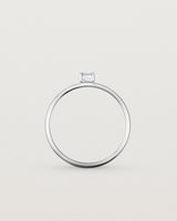 A fine silver ring featuring an emerald cut pale blue sapphire set in the centre of the band