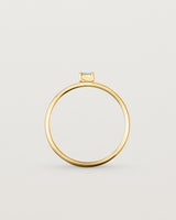 fine yellow gold ring featuring a emerald cut pale blue sapphire