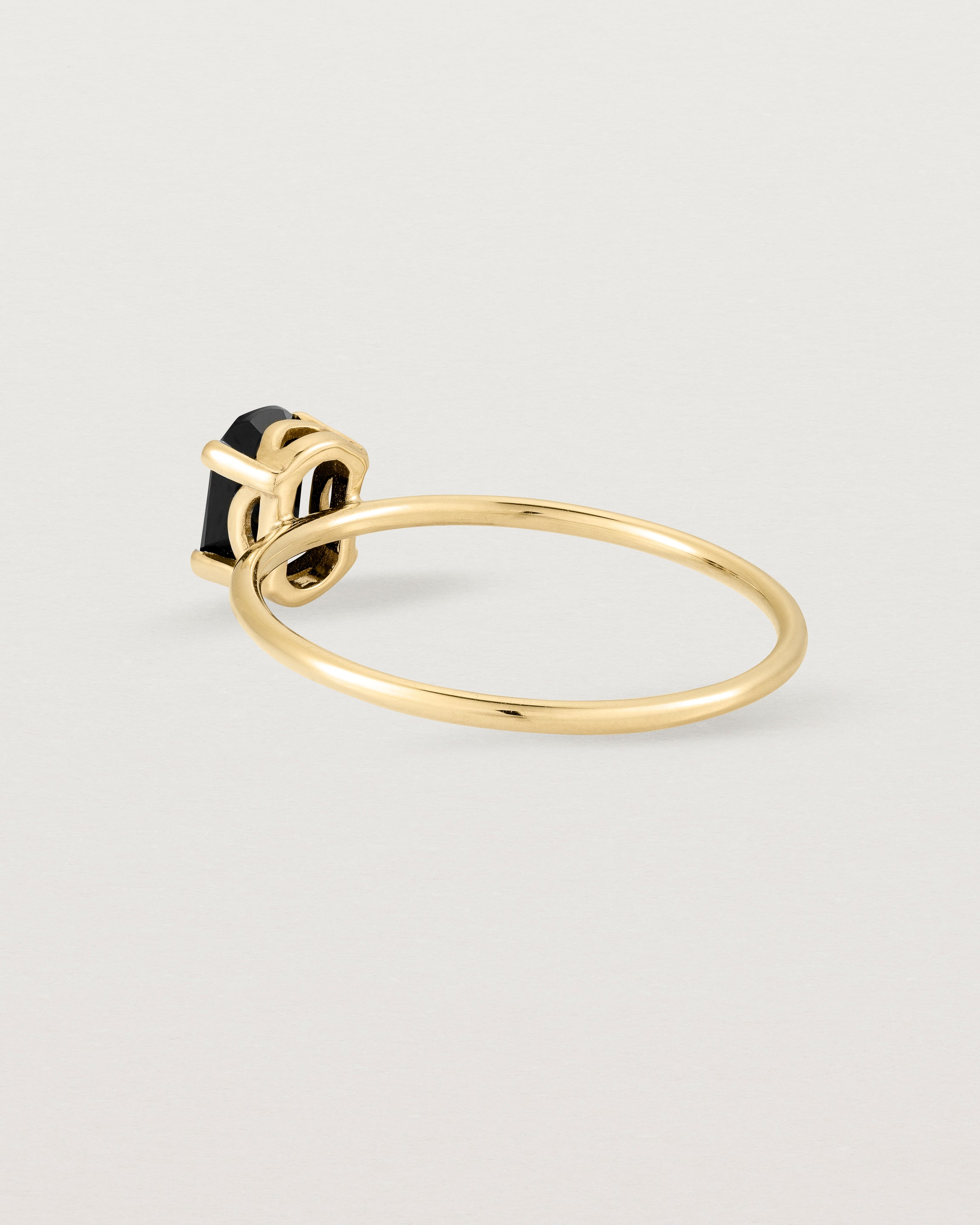 Fine yellow gold band featuring an oval black spinel stone