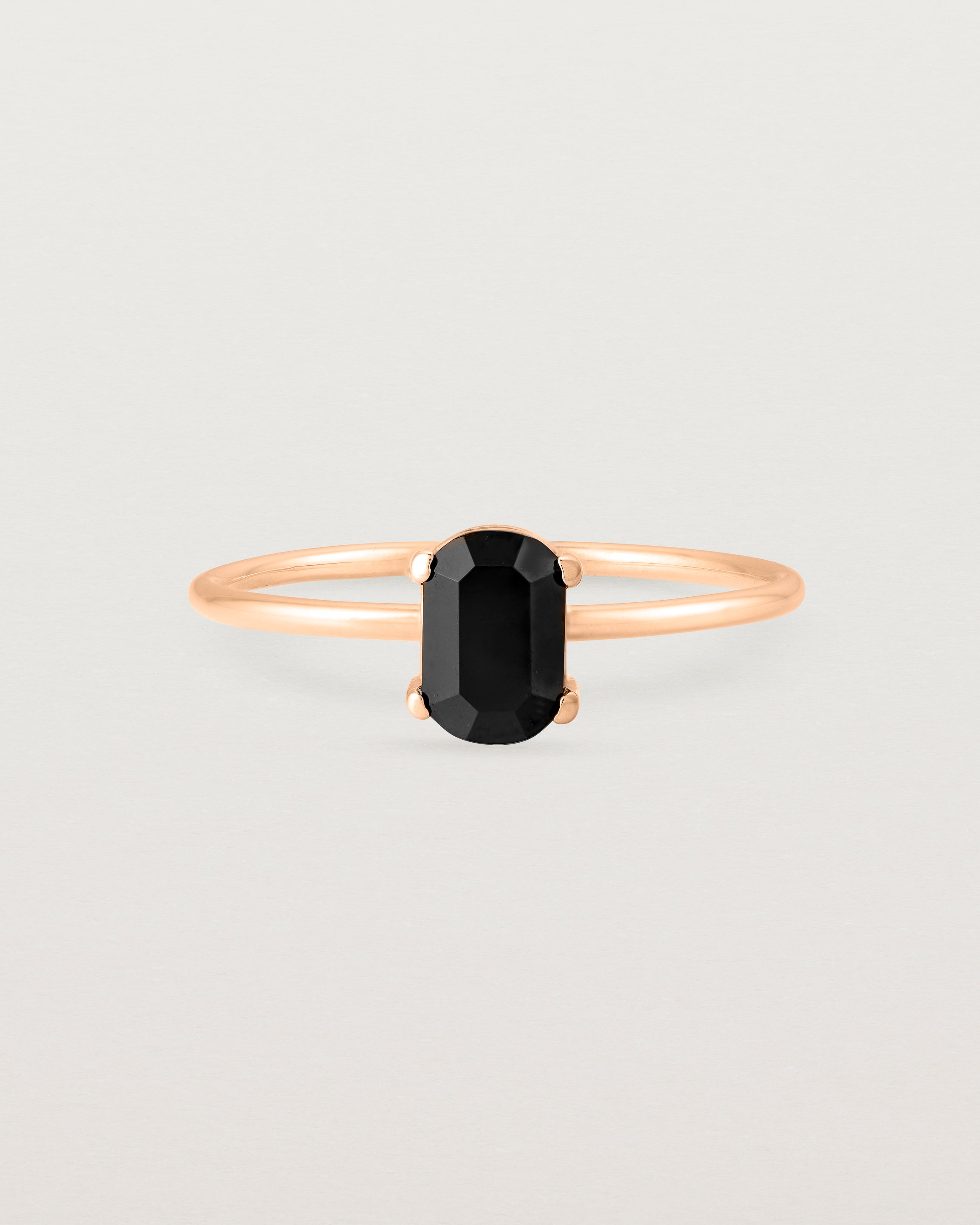 Fine rose gold band featuring an oval black spinel stone