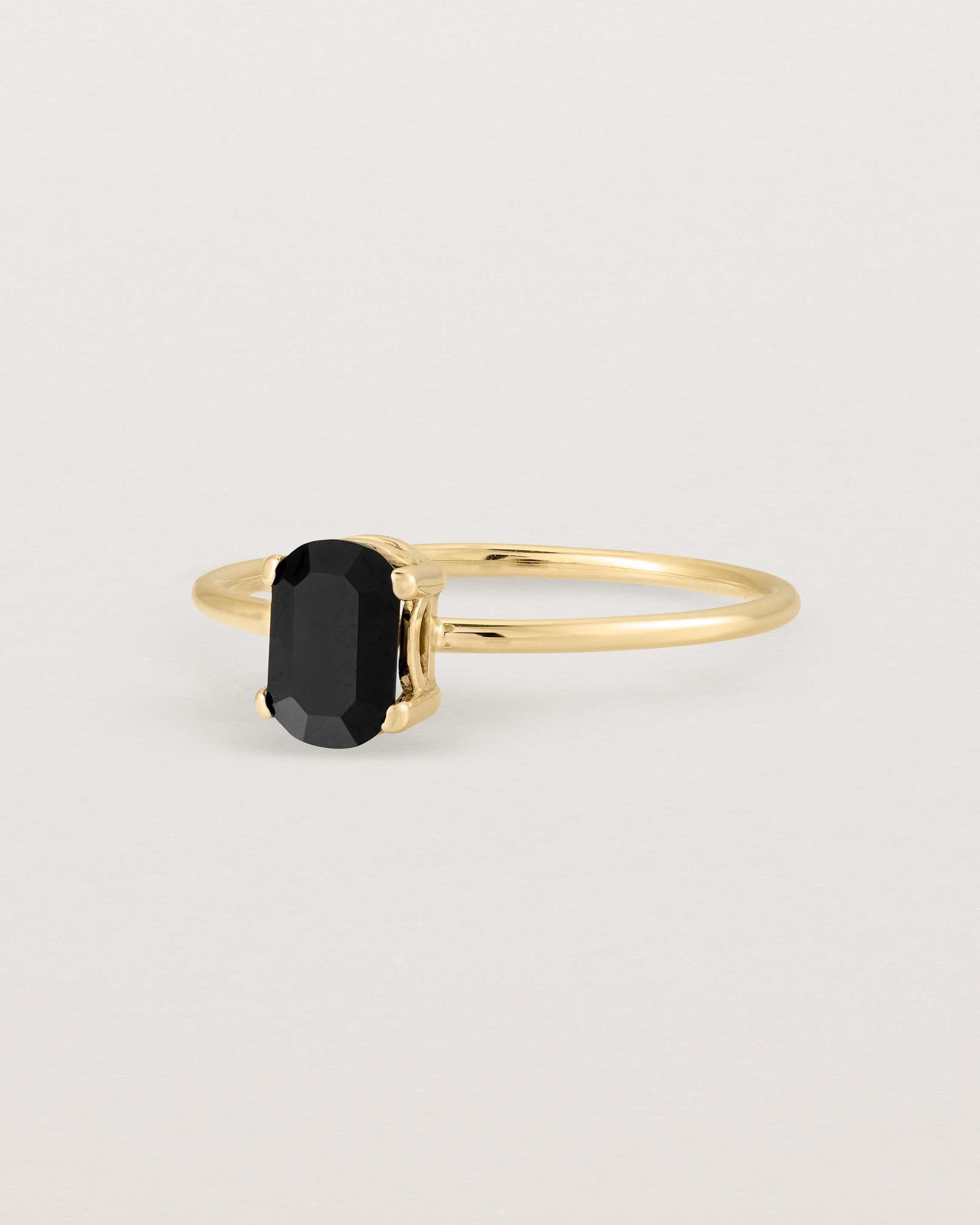 Fine yellow gold band featuring an oval black spinel stone