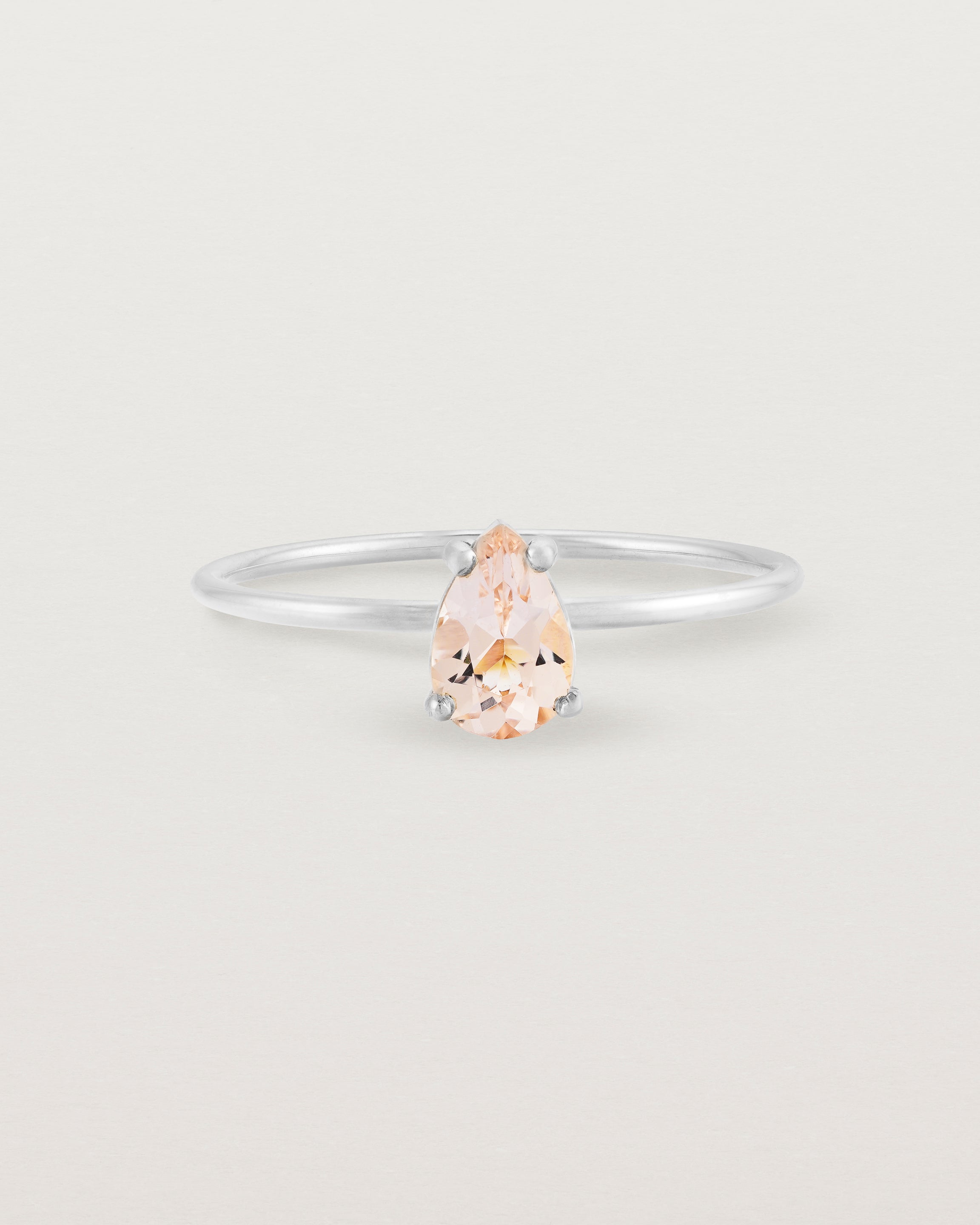 A fine white gold ring featuring a pear shaped pink morganite stone