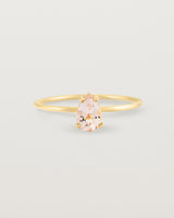 A fine yellow gold ring featuring a pear shaped pink morganite stone