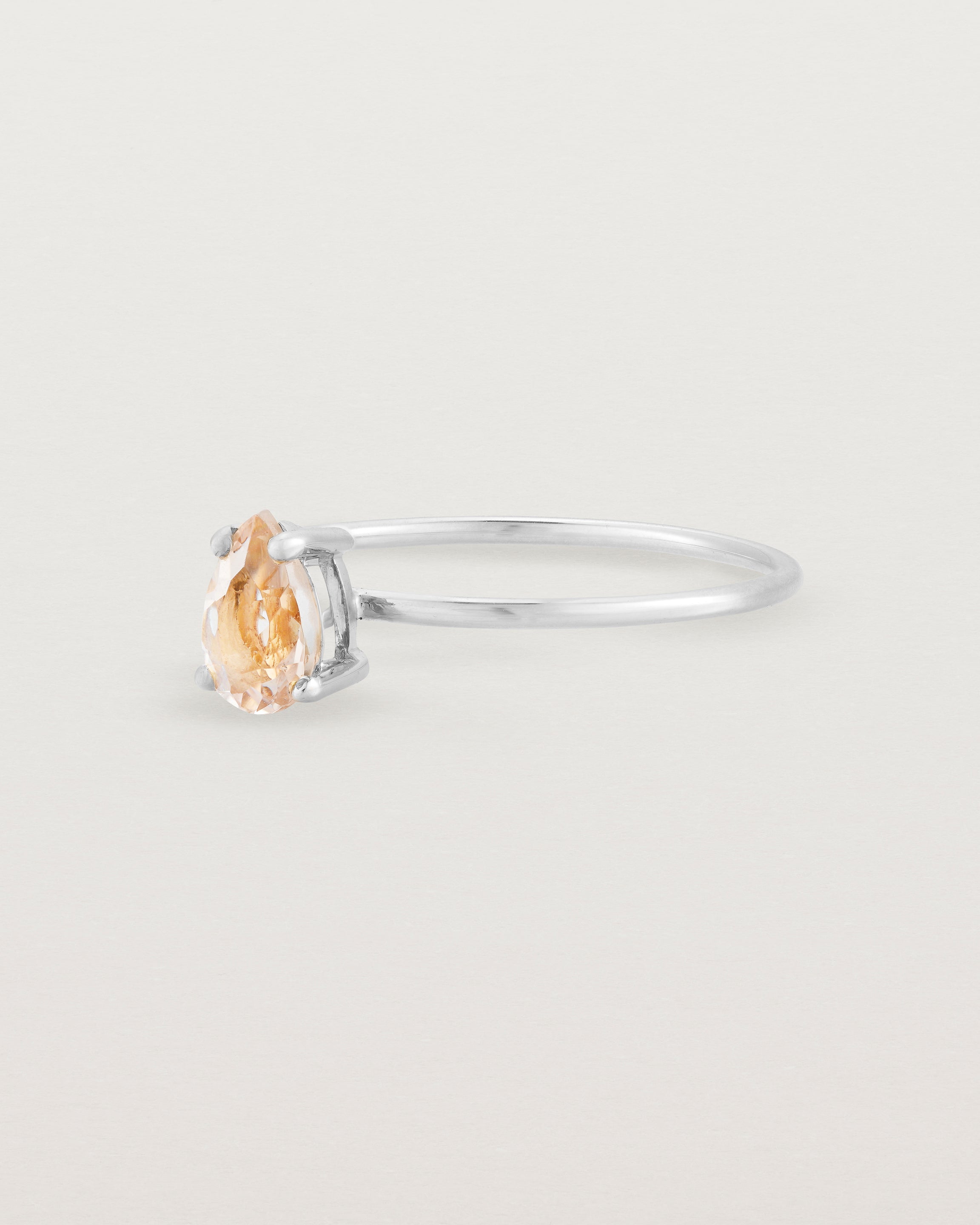 A fine white gold ring featuring a pear shaped pink morganite stone