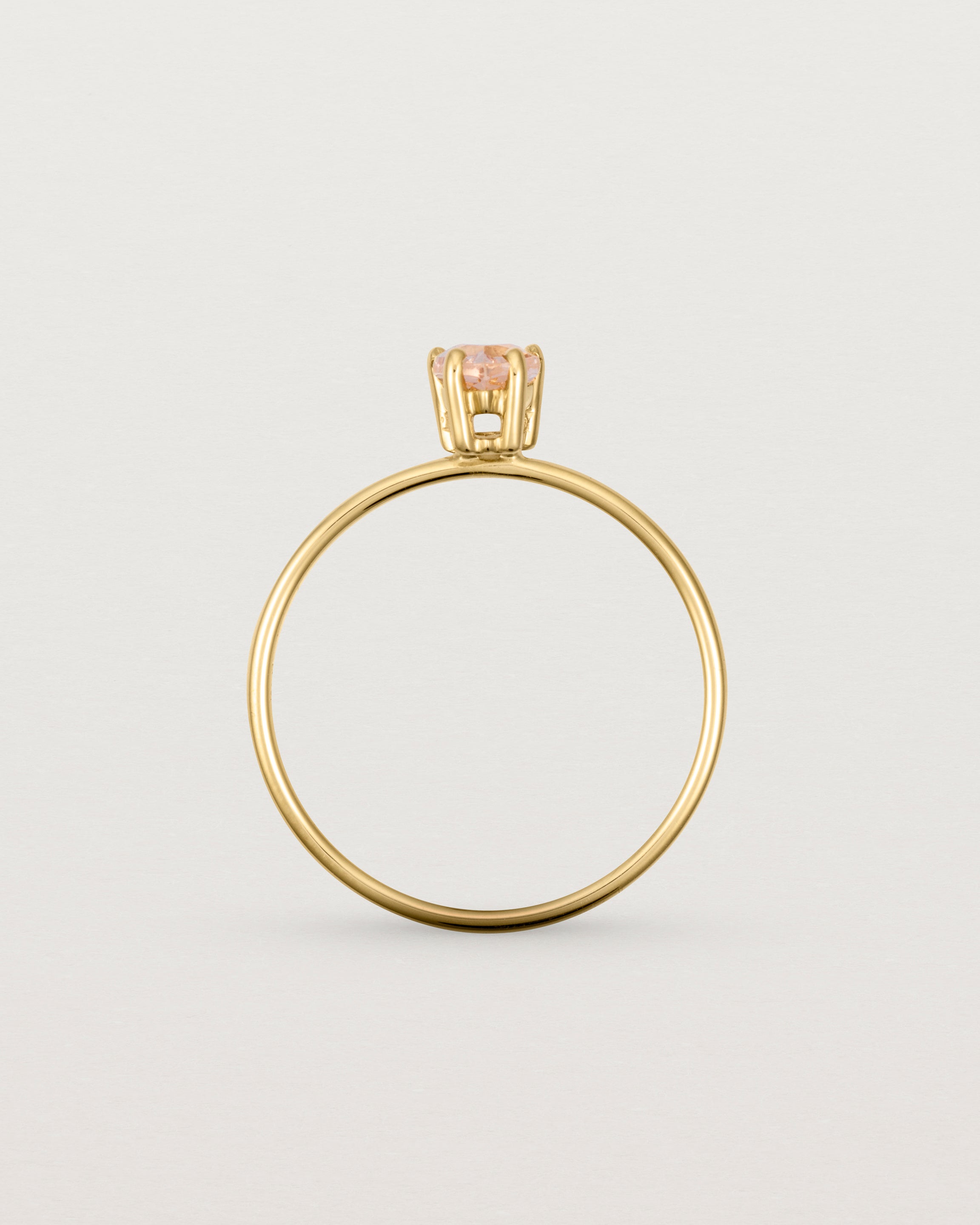 A fine yellow gold ring featuring a pear shaped pink morganite stone