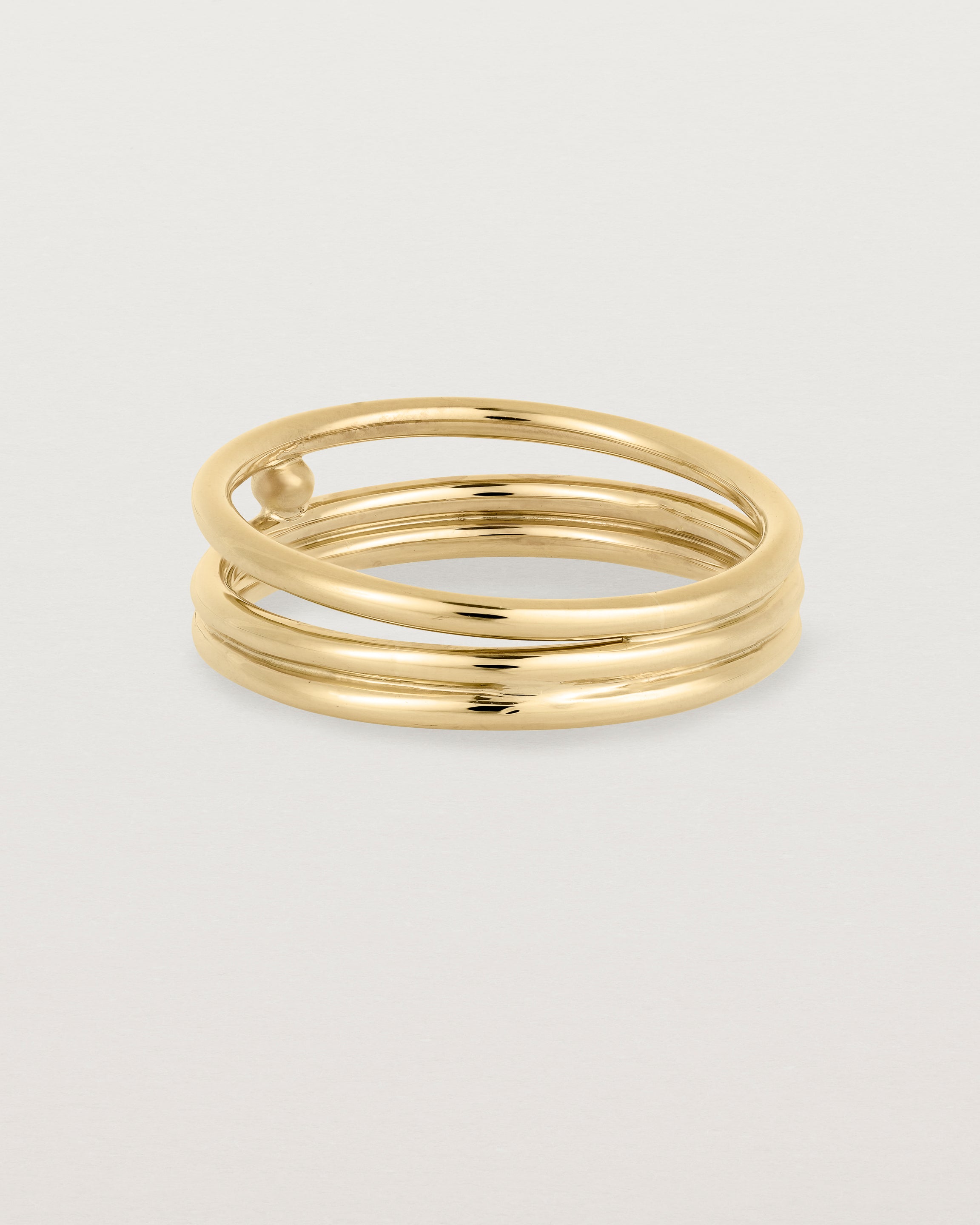 layered yellow gold ring featuring a yellow gold ball suspended between two bands