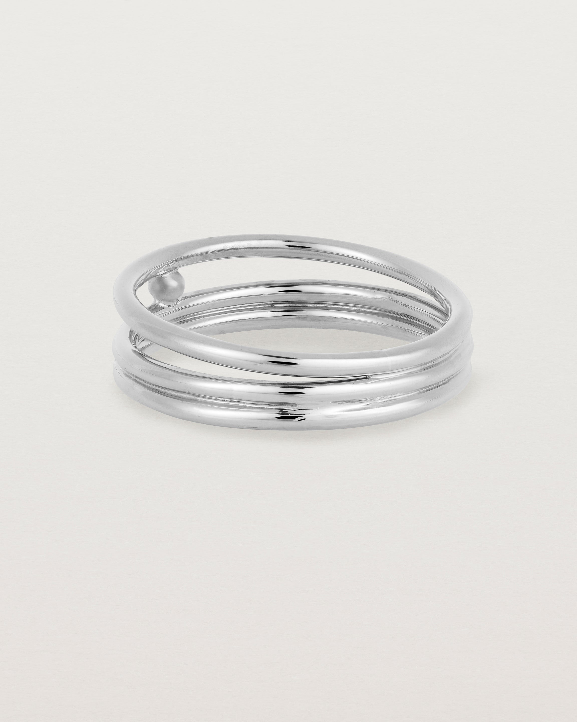 layered silver ring featuring a yellow gold ball suspended between two bands