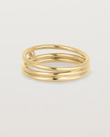 layered yellow gold ring featuring a yellow gold ball suspended between two bands