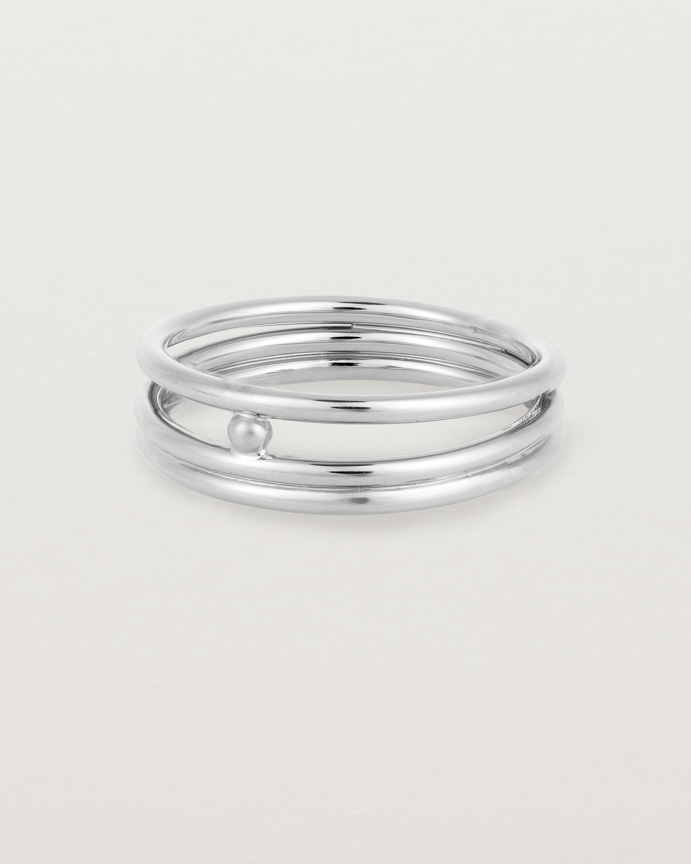 layered silver ring featuring a yellow gold ball suspended between two bands