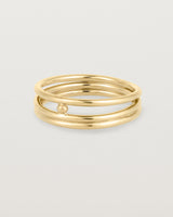layered yellow gold ring featuring a yellow gold ball suspended between two bands