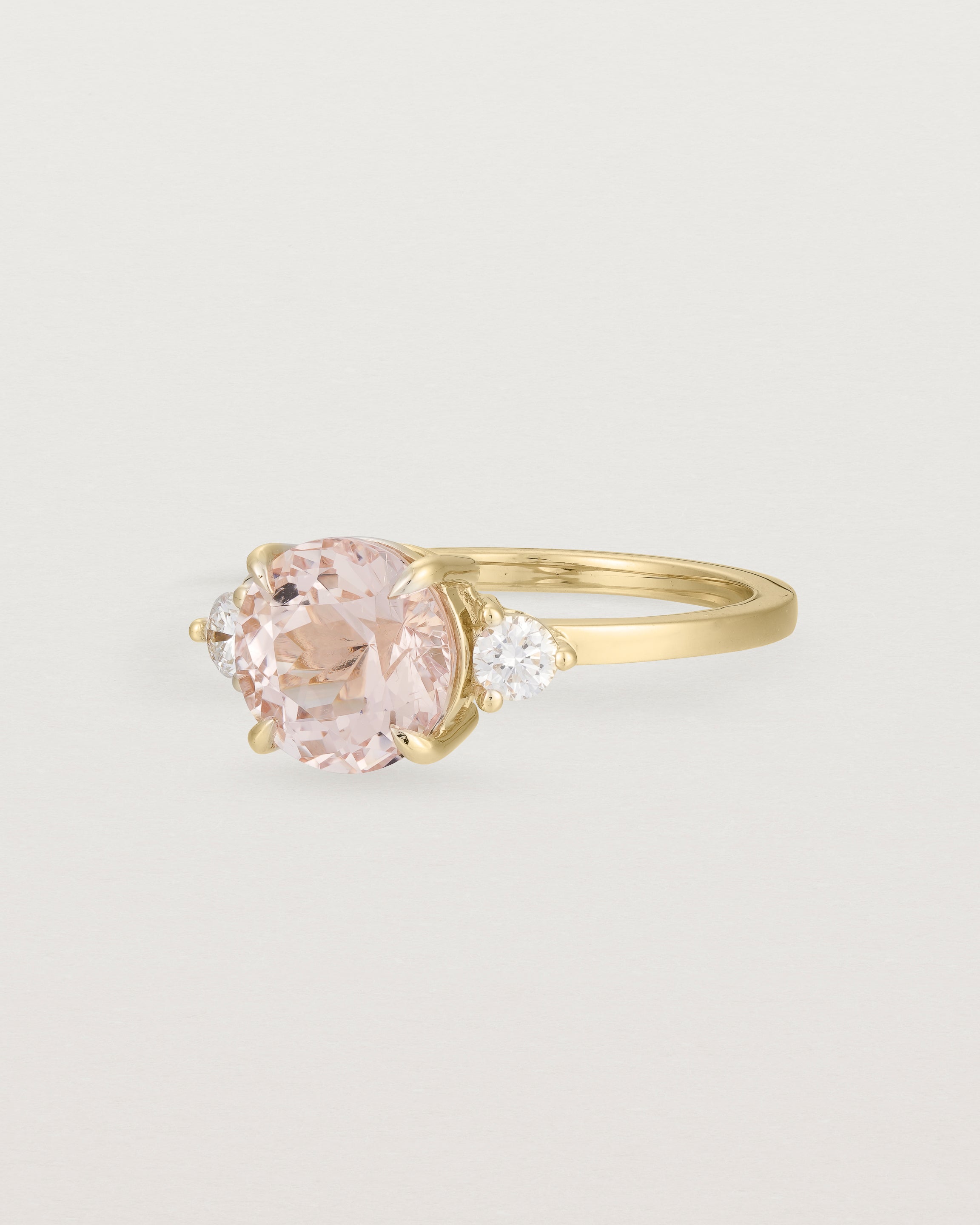 Angled view of the Una Round Trio Ring | Morganite & Diamonds | Yellow Gold. 